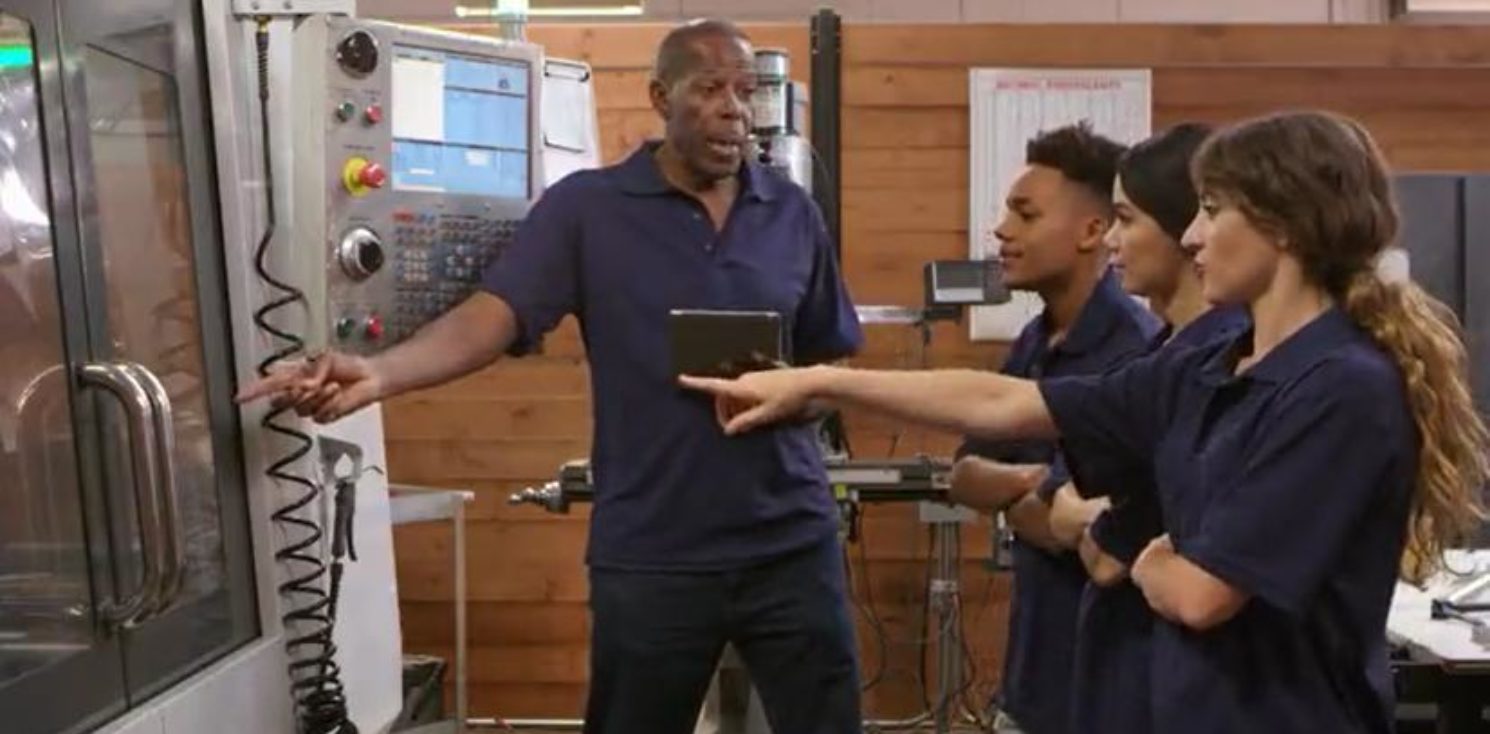 Apprentices being shown how a machine works