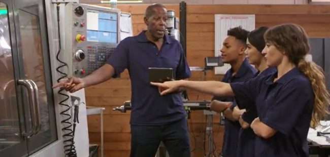 Apprentices being shown how a machine works