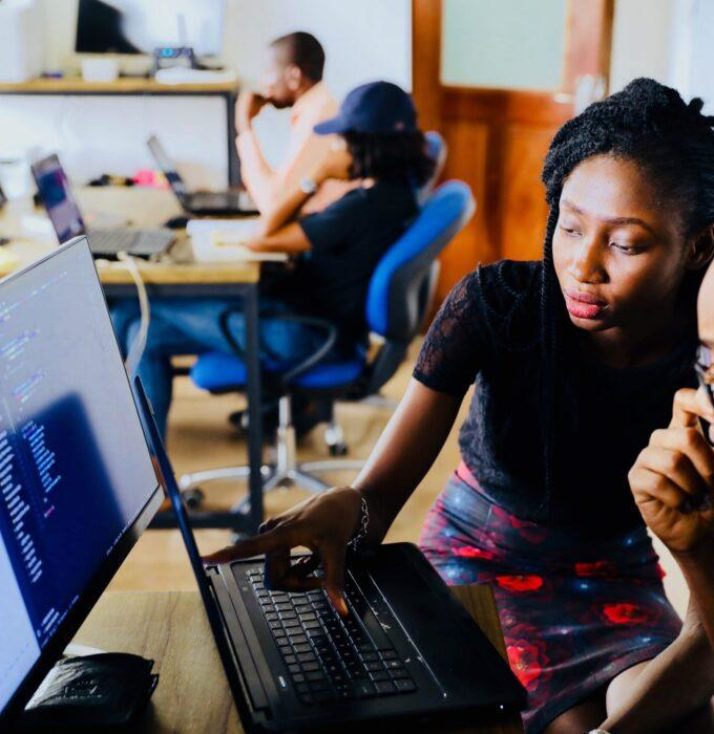 A student and mentor look at a computer screen