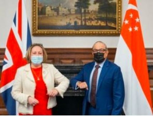 United Kingdom and Singapore flags with country representatives standing in front of them for a new trade deal